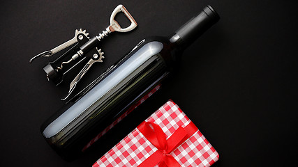 Image showing Red wine bottle, corkscrew and boxed christmas gift
