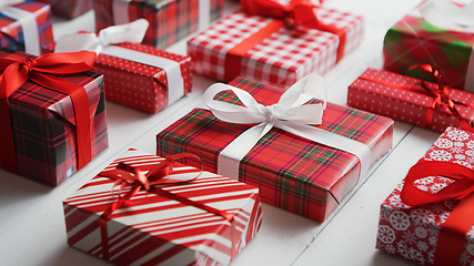 Image showing Side view of wrapped Christmas presents laid on the wooden table