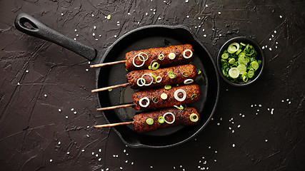 Image showing Barbecued turkey kebab decorated with fresh onion