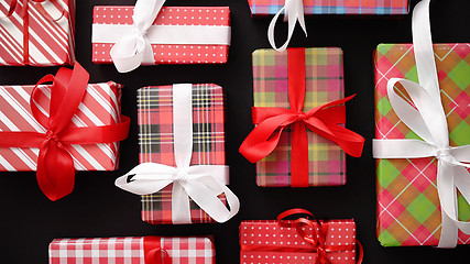 Image showing Top view of wrapped Christmas presents laid on the black background