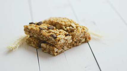 Image showing Granola bars with dried fruits wooden background