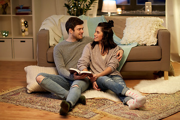 Image showing happy couple reading book at home