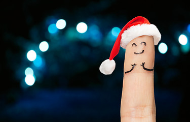 Image showing close up of finger in santa hat over lights