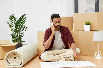 Image showing man with blueprint and boxes moving to new home