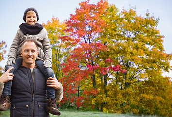 Image showing happy father carrying son over autumn park