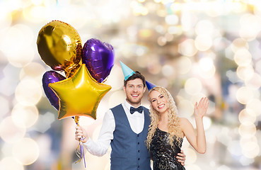 Image showing happy couple with party caps and balloons