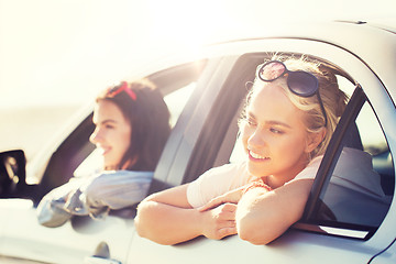 Image showing happy teenage girls or women in car at seaside