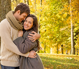 Image showing smiling couple hugging in autumn park