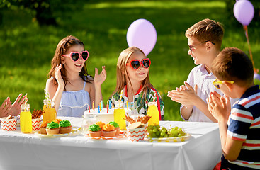 Image showing happy kids with cake on birthday party in summer