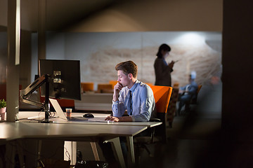 Image showing man working on computer in dark office