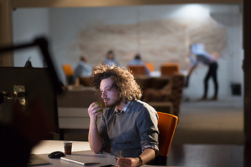 Image showing man working on computer in dark office