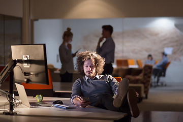 Image showing businessman sitting with legs on desk at office