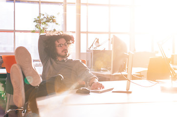 Image showing businessman sitting with legs on desk