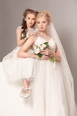 Image showing Little pretty girls with flowers dressed in wedding dresses