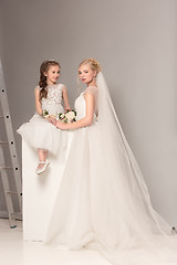 Image showing Little pretty girls with flowers dressed in wedding dresses