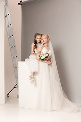 Image showing Little pretty girls with flowers dressed in wedding dresses