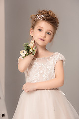 Image showing Little pretty girl with flowers dressed in wedding dresses