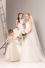 Image showing Little pretty girls with flowers dressed in wedding dresses