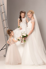 Image showing Little pretty girls with flowers dressed in wedding dresses