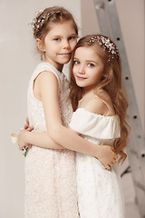 Image showing Little pretty girls with flowers dressed in wedding dresses