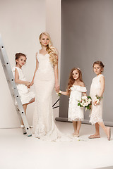 Image showing Little pretty girls with flowers dressed in wedding dresses