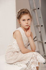 Image showing Little pretty girl with flowers dressed in wedding dresses