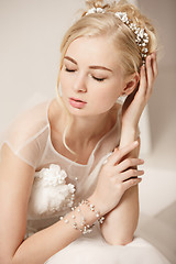 Image showing Bride in beautiful dress standing indoors in white studio interior like at home. Trendy wedding style shot. Young attractive caucasian model like a bride tender looking.