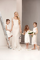 Image showing Little pretty girls with flowers dressed in wedding dresses