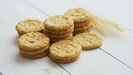 Image showing Healthy oatmeal cookies on white wood background, Side view.