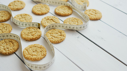 Image showing Healthy oatmeal cookies on white wood background, side view.