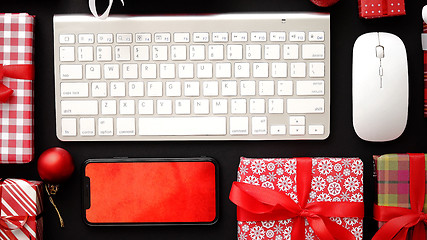 Image showing Computer keyboard, modern smartphone, mouse and christmas boxed gifts