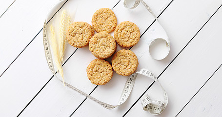 Image showing Healthy oatmeal cookies on white wood background, top view.