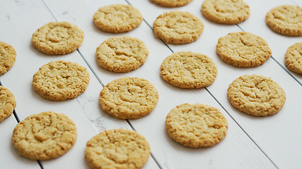 Image showing Healthy oatmeal cookies on white wood background, Side view.