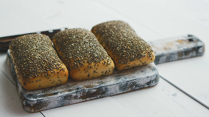 Image showing Closeup of whole grain bread with seeds on a rustic wooden board