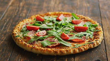 Image showing Delicious italian pizza served on wooden table