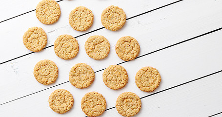 Image showing Healthy oatmeal cookies on white wood background, top view.