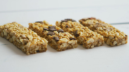 Image showing Granola bars with dried fruits wooden background