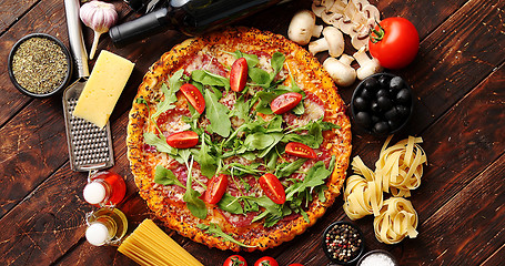 Image showing Italian food background with pizza, raw pasta and vegetables on wooden table