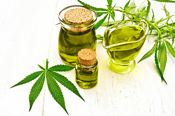 Image showing Oil hemp in gravy boat and two jars on board