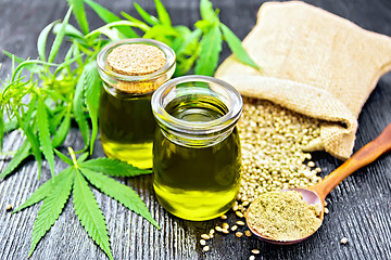 Image showing Oil hemp in two jars and flour in spoon on board