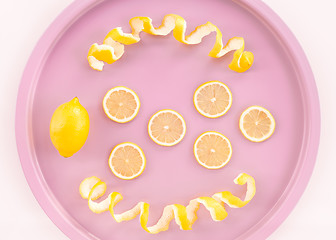 Image showing Lemons and spiral peel on a pink tray