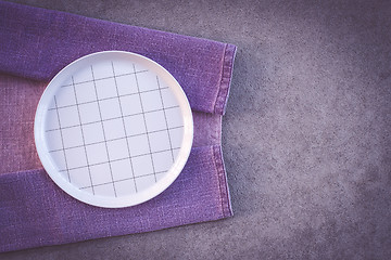 Image showing Checked white plate and purple tablecloth