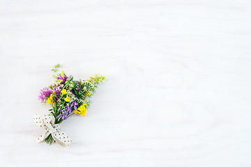 Image showing Bouquet of wild flowers on white wooden background