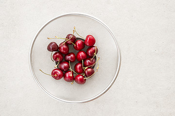 Image showing Fresh cherries in a round colander