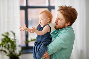 Image showing father and baby daughter with soap bubbles at home