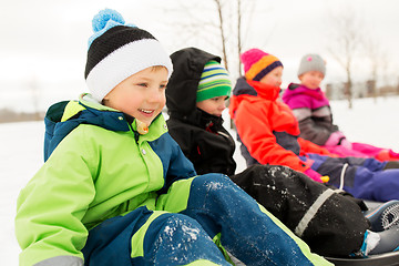 Image showing happy little kids riding sleds in winter