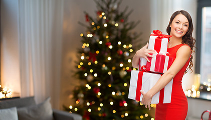 Image showing smiling woman with christmas gifts at home