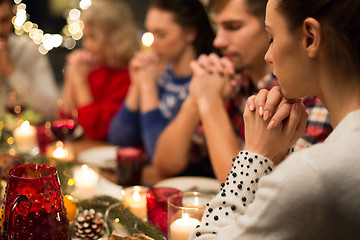 Image showing close up of friends praying at christmas dinner