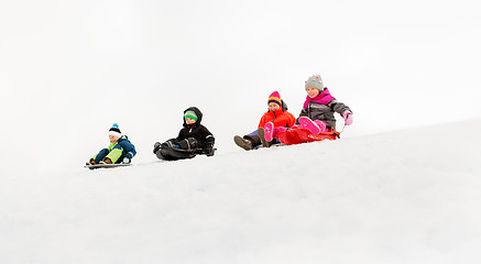 Image showing kids sliding on sleds down snow hill in winter