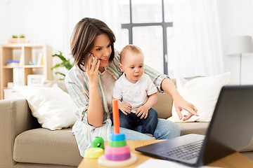 Image showing working mother with baby calling on smartphone